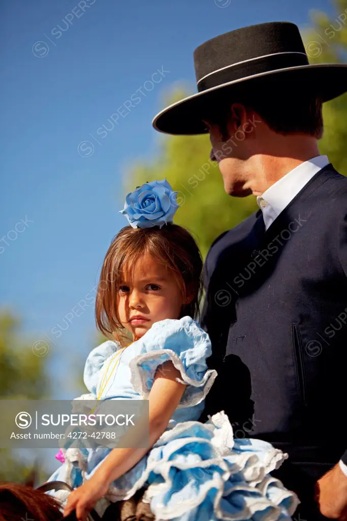 Seville, Andalusia, Spain, A girl with her father in traiditonal clothes at the Feria de Abril