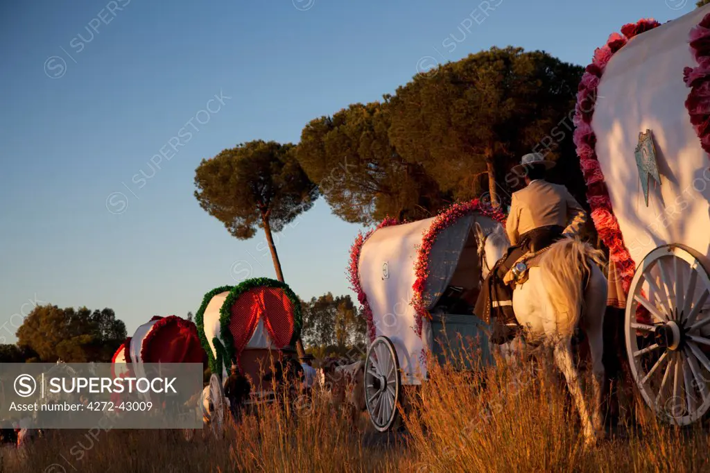 Huelva, Southern Spain. Colourful carriages and man on horseback on the way to the village of El Rocio during the Romeria