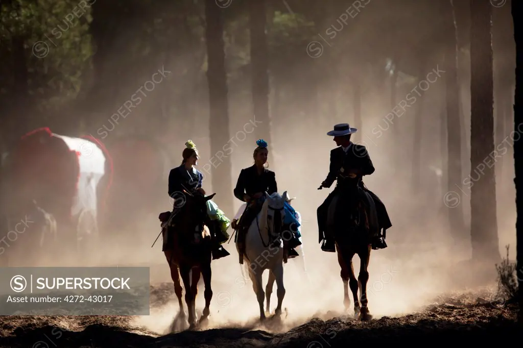 Huelva, Southern Spain. Horse riders passing through the forest on their way to the village of El Rocio during the annaul Romeria