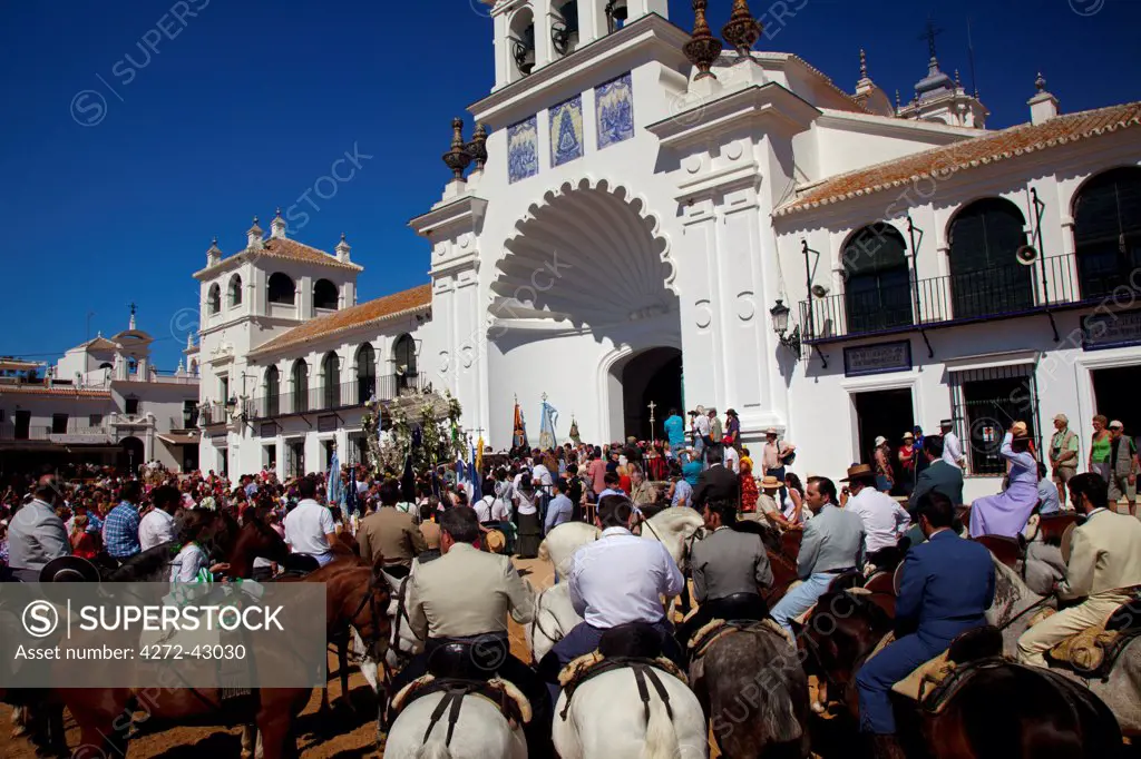 El Rocio, Huelva, Southern Spain. Man in traditional clothes on horseback in front of the main church in the village of El Rocio during the annual Romeria