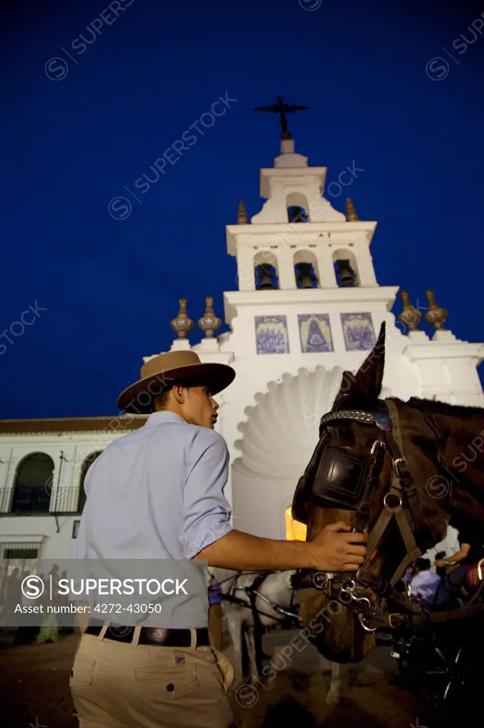 El Rocio, Huelva, Southern Spain. Young man with his horse in front of the church of El Rocio