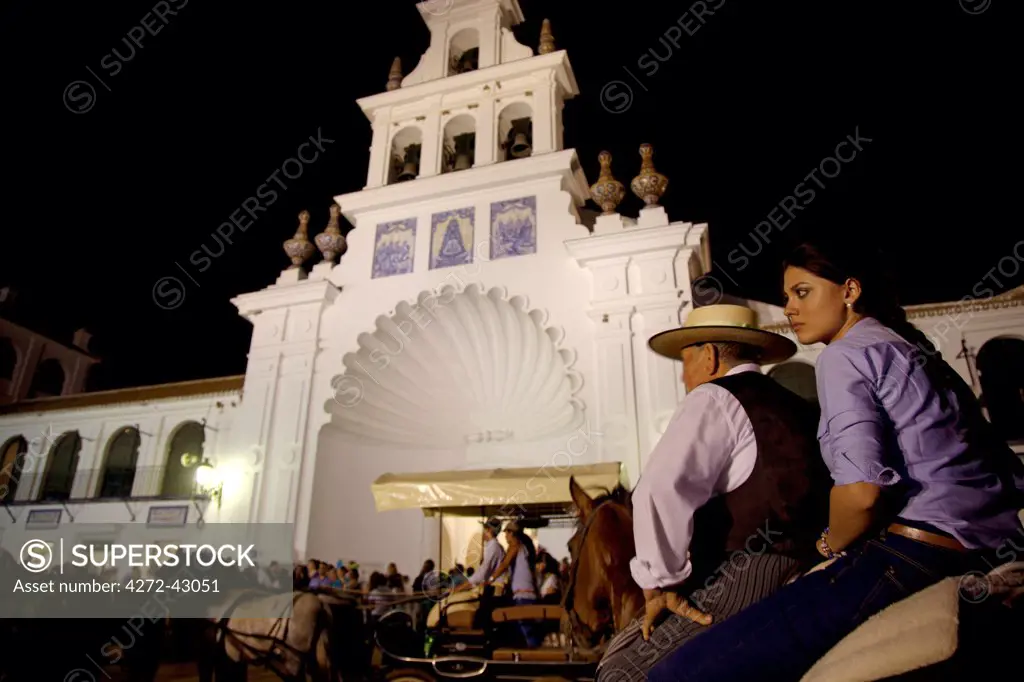El Rocio, Huelva, Southern Spain. A young woman with her father on horseback in front of the church of El Rocio during the annual Romeria