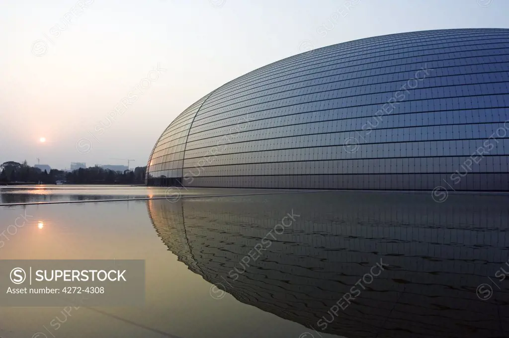 China, Beijing. Sunset at The National Grand Theatre Opera House also known as The Egg designed by French architect Paul Andreu and made with glass and titanium (opened Sept 25th 2007).