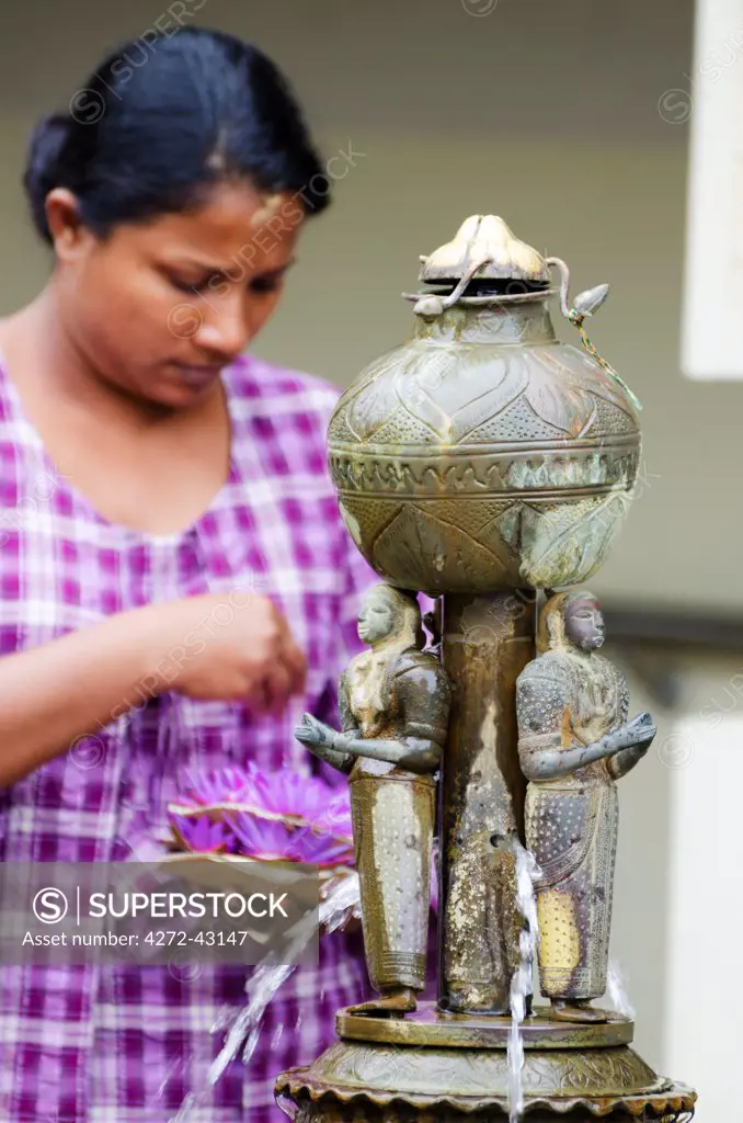Sri Lanka, Sacred city of Kandy, UNESCO World Heritage Site, Temple of the Tooth , Sri Dalada Maligawa, woman at a fountain