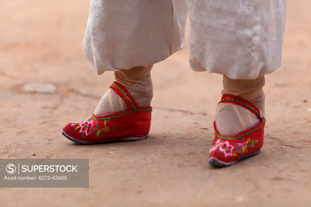 China, Yunnan, Liuyi. Tiny bound feet clad in embroidered shoes in the village of Liuyi.