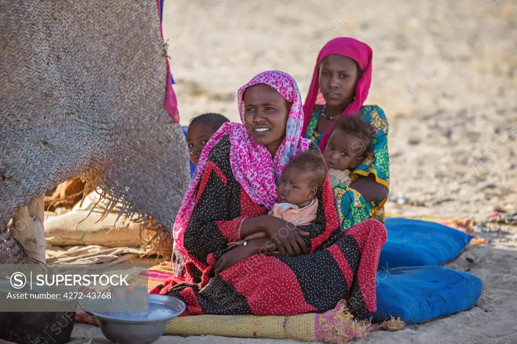 Chad, Kanem, Bahr el Ghazal, Sahel. Young Kreda women and their children at their temporary home made from woven mats.