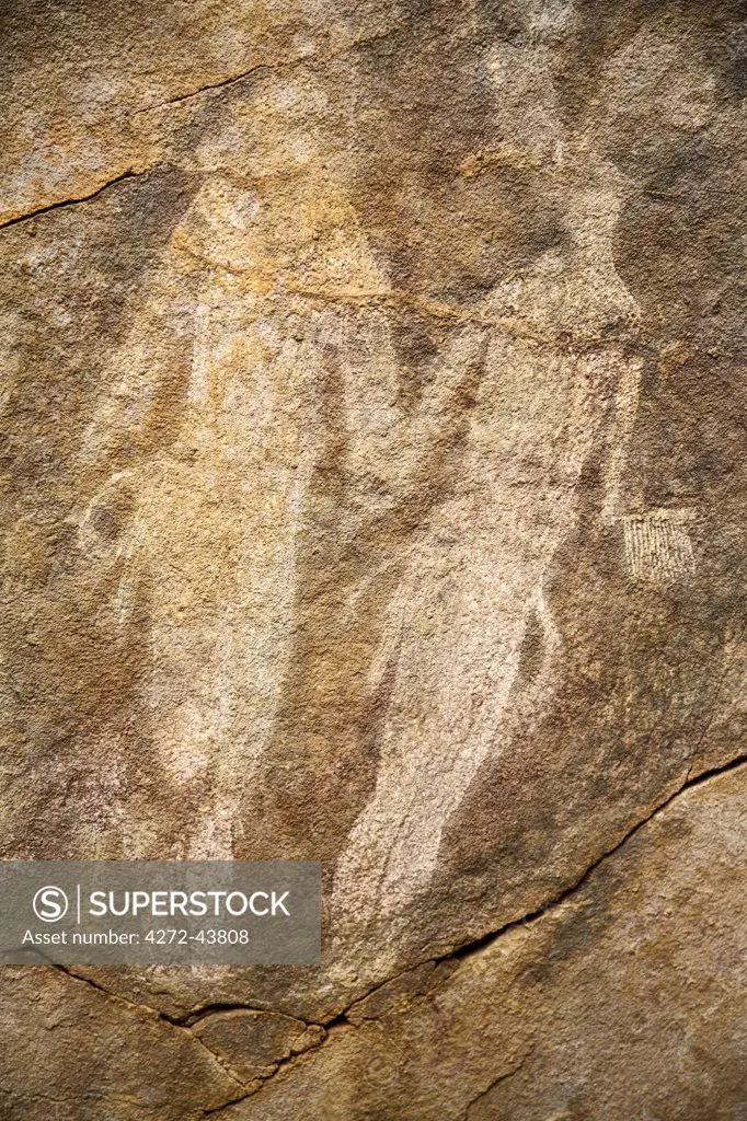 Chad, Elikeo, Ennedi, Sahara. Two large white figures painted on the ceiling of a rock shelter.
