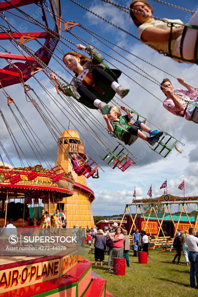 UK, Wiltshire. Children enjoy the chair O plane ride at a traditional steamfair.