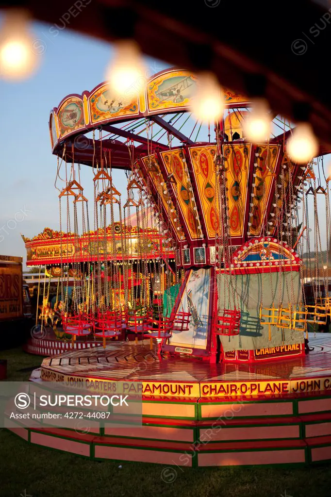 UK, Wiltshire. Chair O planes and pony carousel rides at a traditional English steamfair.