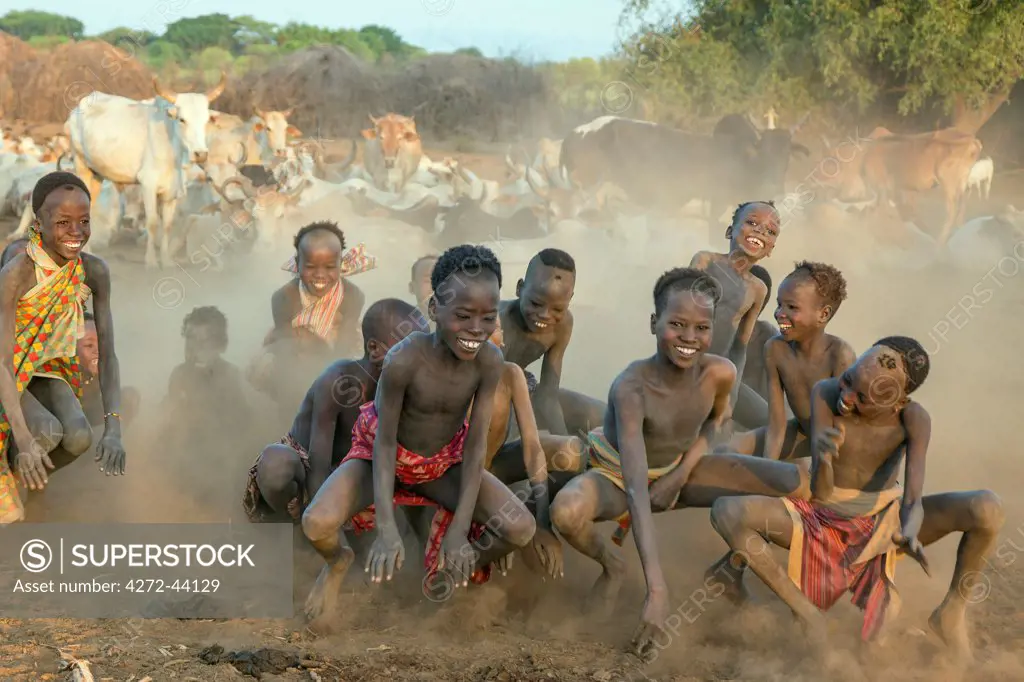 Exuberant Dassanech boys have fun playing a game that imitates the jumping movement of grasshoppers and frogs, Ethiopia