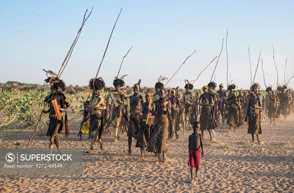 Dassanech men and women dressed in ceremonial Dimi regalia in preparation for a dance, Ethiopia