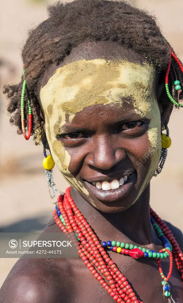 A Dassanech woman with yellow ochre on her face in preparation for a Dimi ceremony, Ethiopia