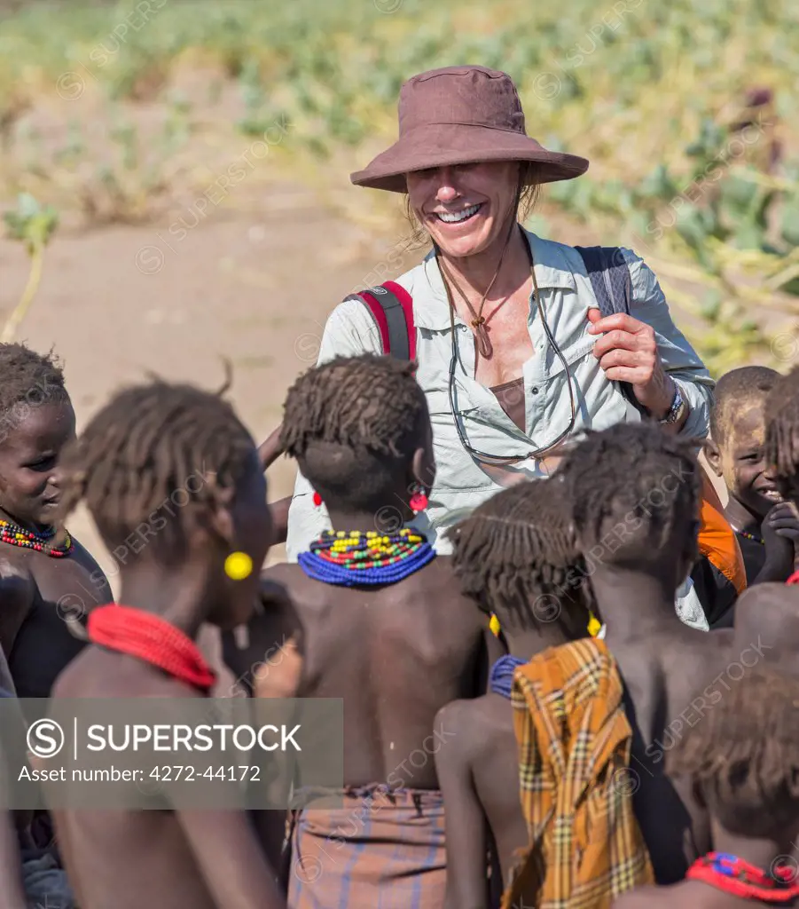 Dassanech children crowd round a visitor to their village in the Omo Delta, Ethiopia