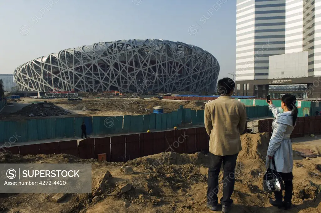 China, Beijing, Olympic Park. Chinese people trying to get an early look at the National Stadium for the 2008 Beijing Olympics.