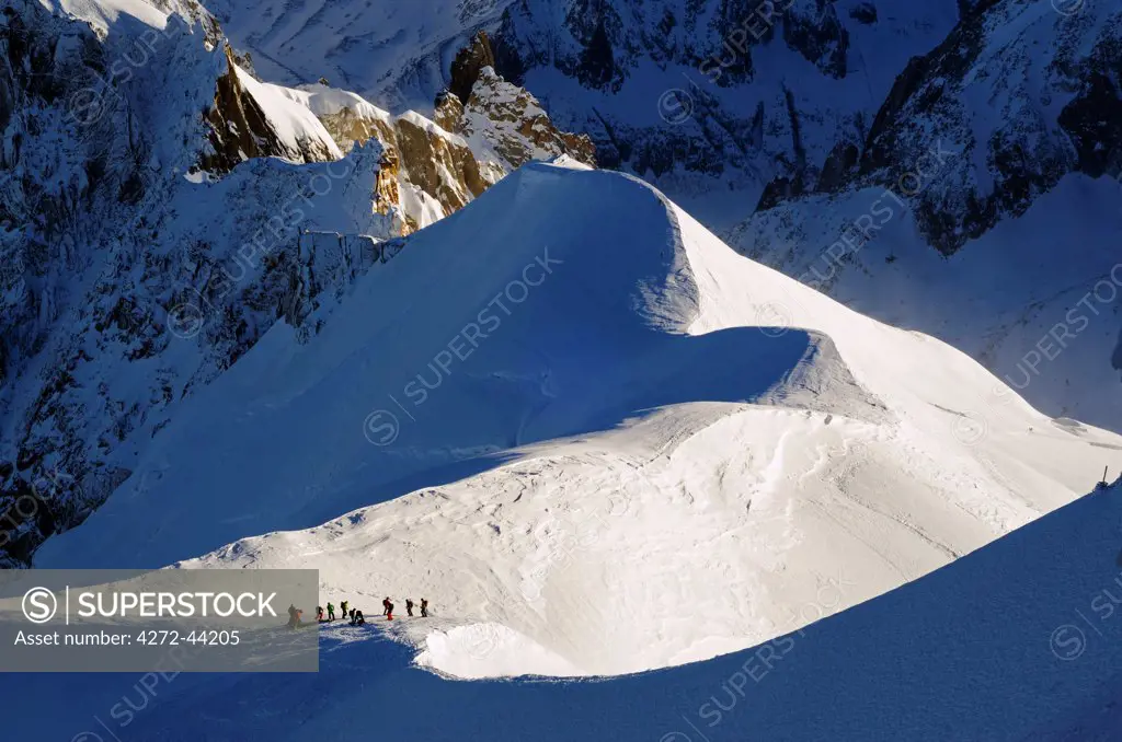 Europe, France, French Alps, Haute Savoie, Chamonix, Aiguille du Midi, skiers walking down the ridge at the start of Vallee Blanche off piste
