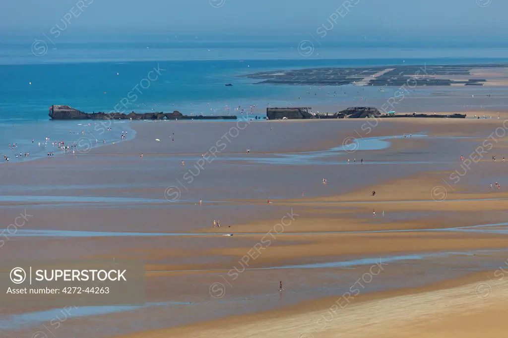 Remnants of the D Day British controlled Mulberry Harbour System lie littered across Gold Beach at Arromanches les Bains, Basse Normandie, France