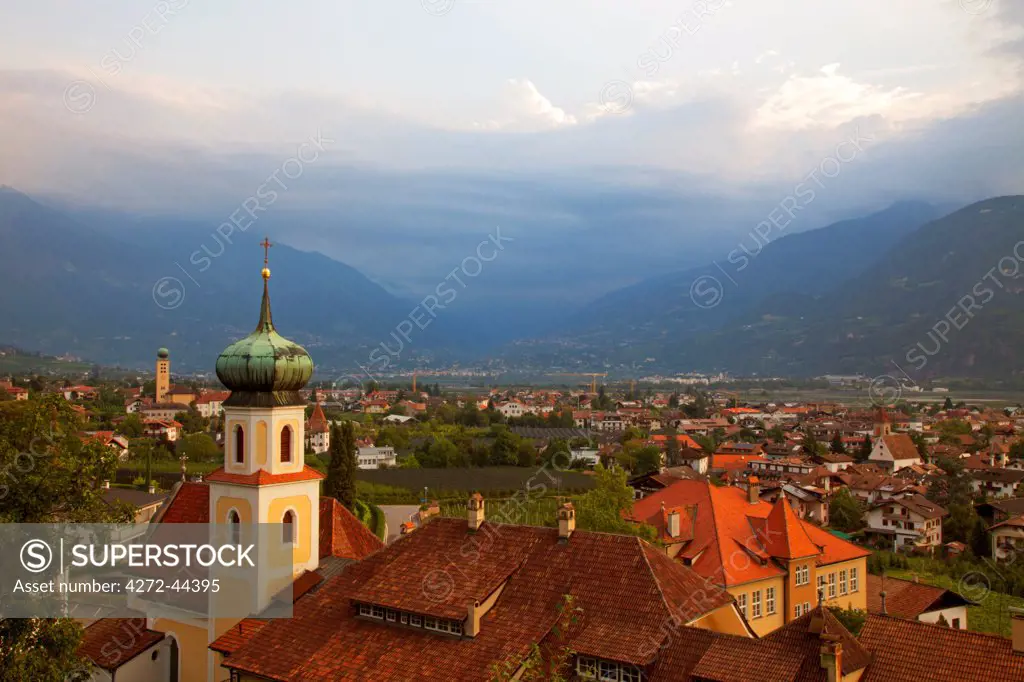 Northern Italy, Trentino, Alto Adige, Sud Tyrol. Overview of the town of Lana with a church in the foreground and mountains in the background