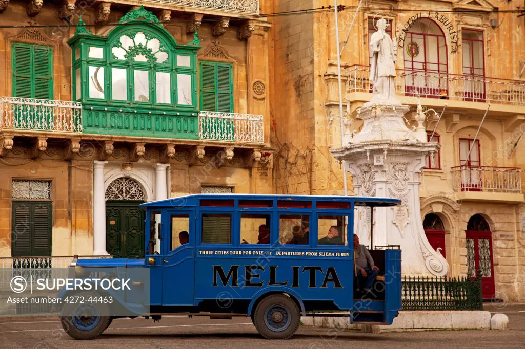 Mediterranean Europe, Malta. A vintage bus dating back to the British rule, today used to transport tourists, in a village square