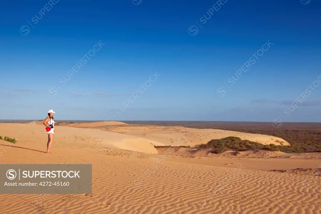 South America, Brazil, Ceara, Morro Branco, a photographer looks out over the dry sertaon scenery in coastal Ceara from the top of high sand dunes MR