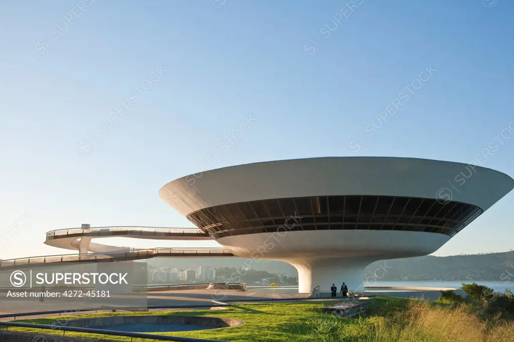 South America, Rio de Janeiro, Niteroi, Oscar Niemeyers Contemporary Art Museum, MAC Niteroi, in the late afternoon light, with Guanabara Bay and the Sugar Loaf, Pao de Acucar, in the background