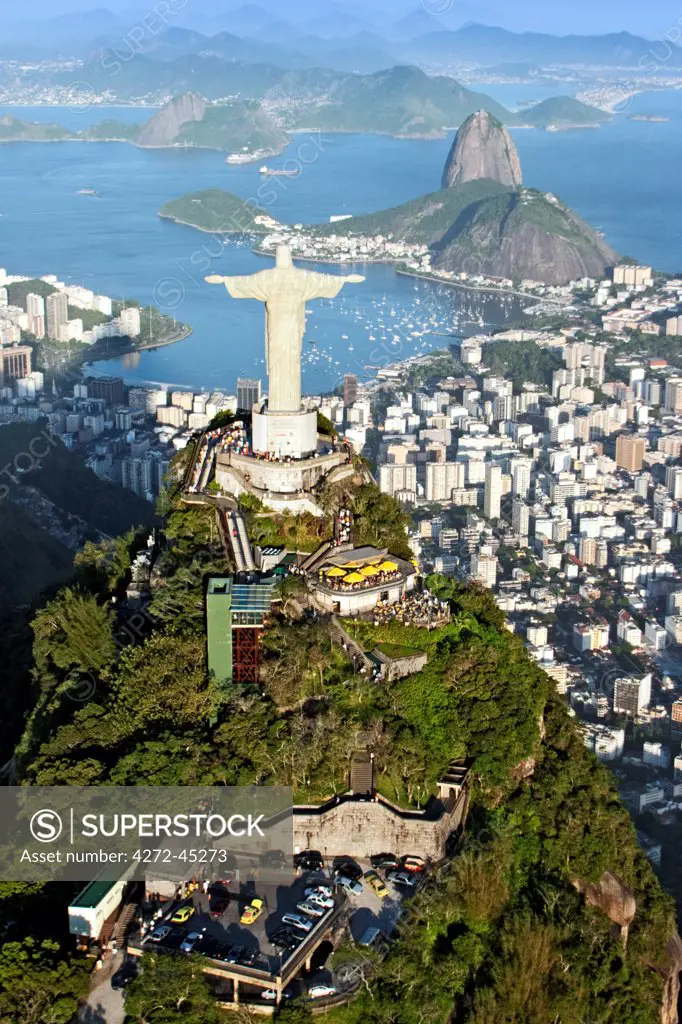 South America, Brazil, Rio de Janeiro state, Rio de Janeiro city, Aerial view of Corcovado mountain and Christ the Redeemeer, Cristo Redentor, showing rainforest setting and Sugar Loaf in the background