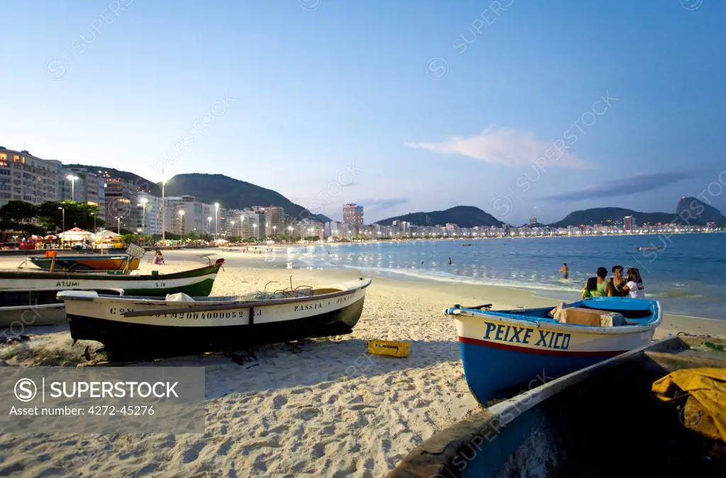 South America, Rio de Janeiro, Rio de Janeiro city, fishing boats at the far end of Copacabana Beach with Copacabana and the Morro do Leme hill in the background