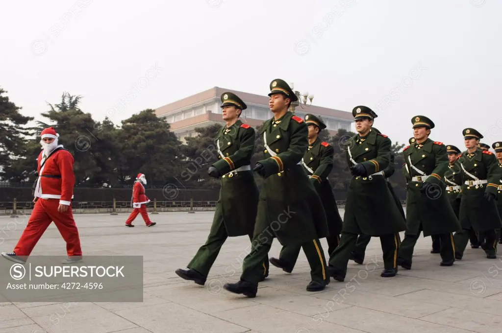 China, Beijing, Tiananmen Square. Foreign residents dressed up as Santa on Christmas Day marching in line with National Guards.