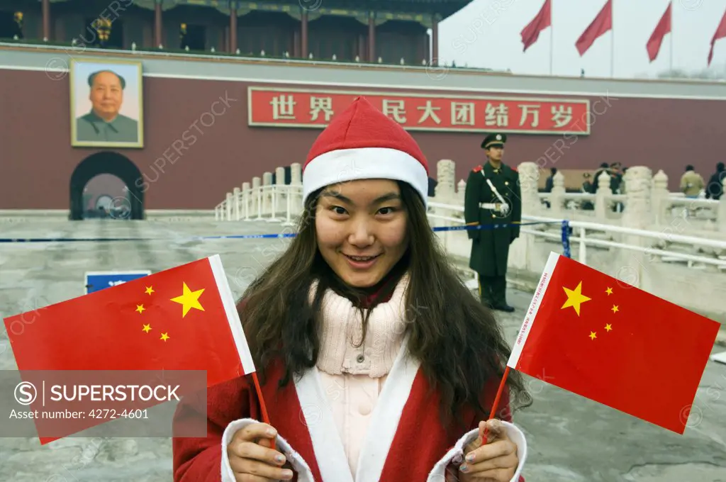 China, Beijing, Tiananmen Square. A Chinese girl dressed up as Santa on Christmas Day (MR).