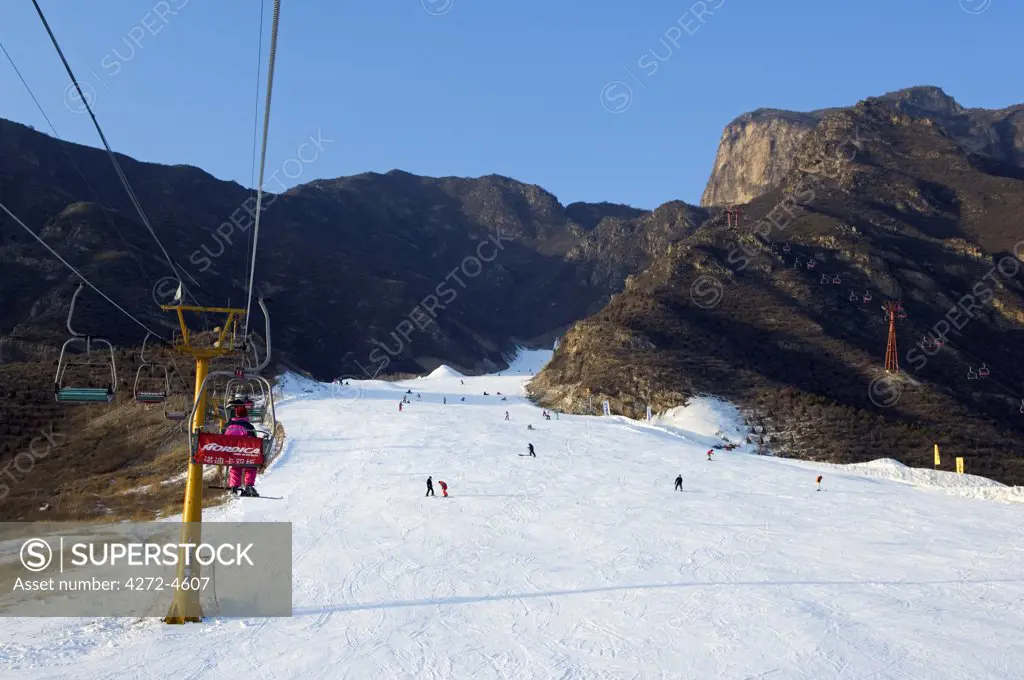 China, Beijing, Shijinglong ski resort. A ski lift taking skiers up to the slopes.