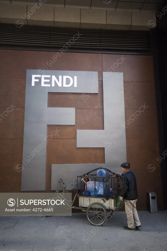 China, Beijing. New luxury brand Fendi department store and a water delivery man with bicycle.