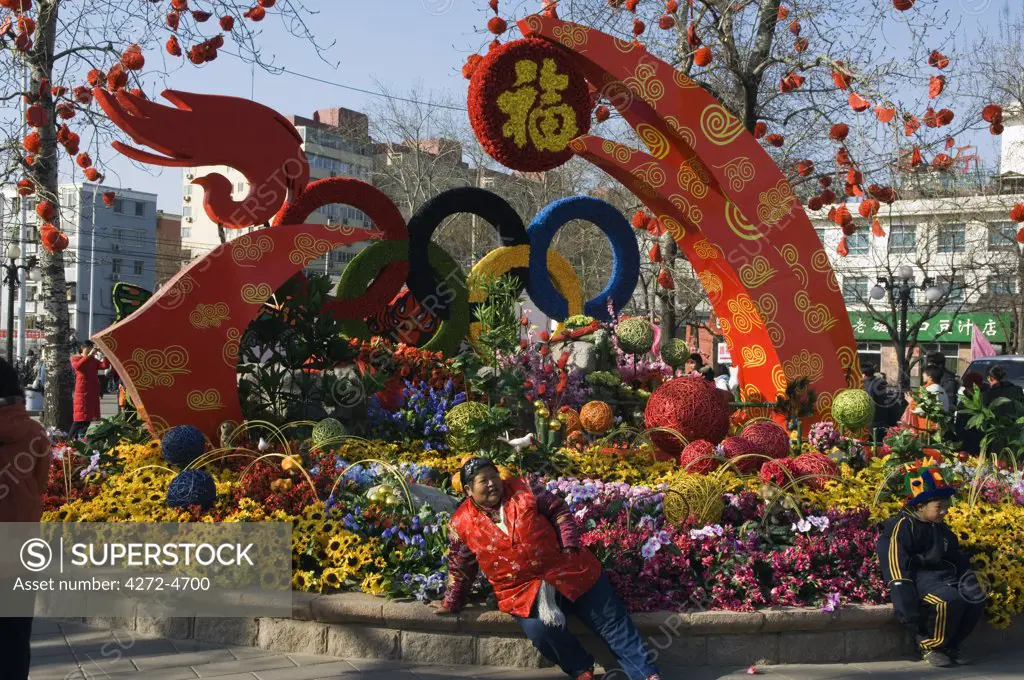 China, Beijing. Chinese New Year Spring Festival - flower decorations and a lady relaxing.