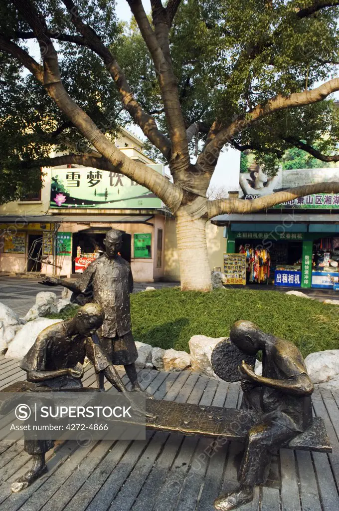 China, Zhejiang Province, Hangzhou. West Lake bronze statues of children playing.