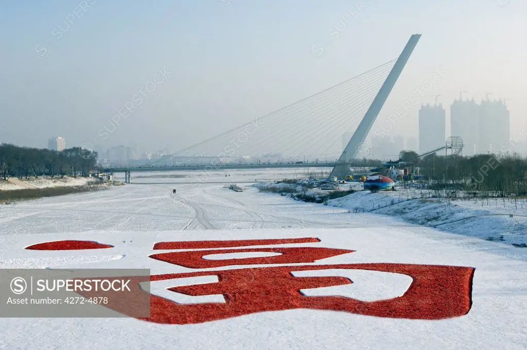 China, Northeast China, Heilongjiang Province, Harbin City. Snow and Ice Sculpture Festival at Sun Island Park. A sign of good luck and fortune near a bridge at the park entrance.
