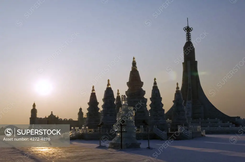 China, Northeast China, Heilongjiang Province, Harbin City. Ice Lantern Festival. Sunset on an ice sculpture replica of Bangkok's Wat Po.