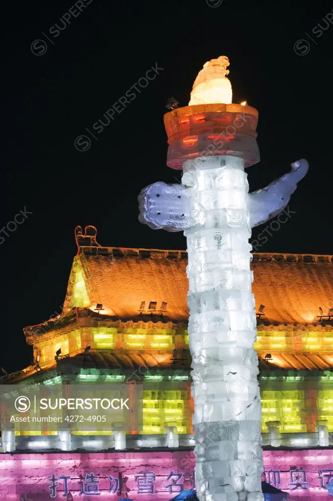 China, Northeast China, Heilongjiang Province, Harbin City. Ice Lantern Festival. A colourful ice sculpture replica of the Forbidden City's Huabiao statue and Gate of Heavenly Peace in Beijing illuminated at night.