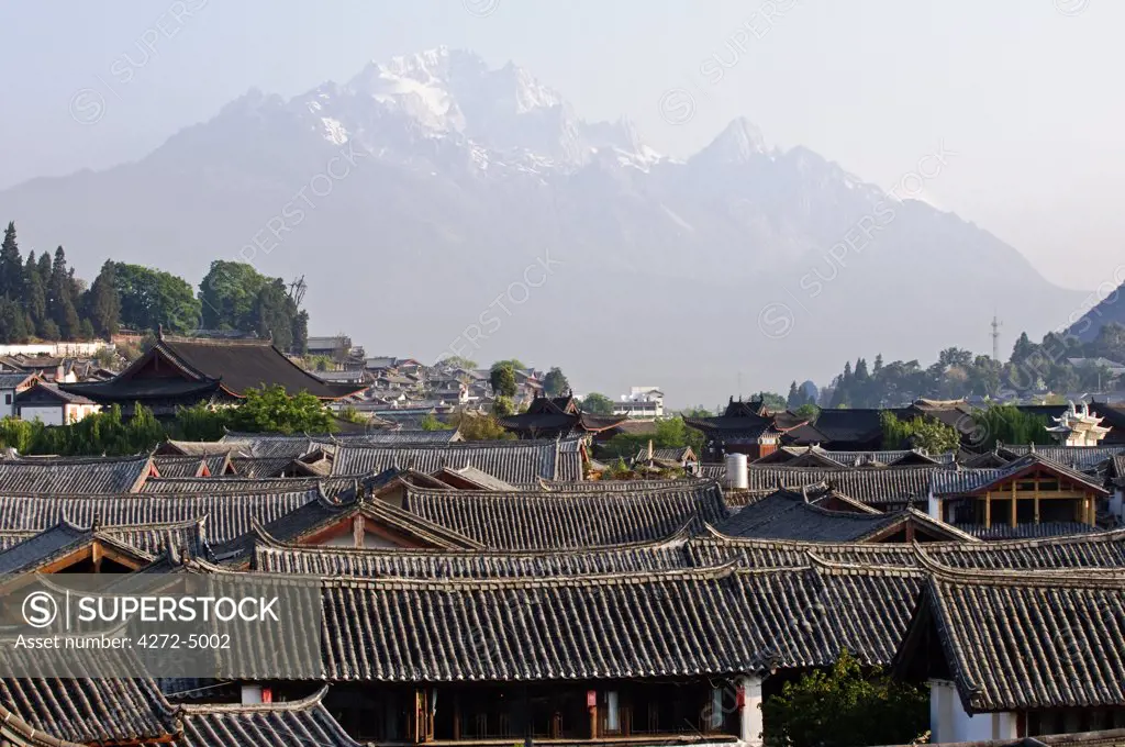 China, Yunnan province, Lijiang old town rooftops and Jade Peak Snow Mountain (Yulong Xueshan), Unesco World Heritage Site