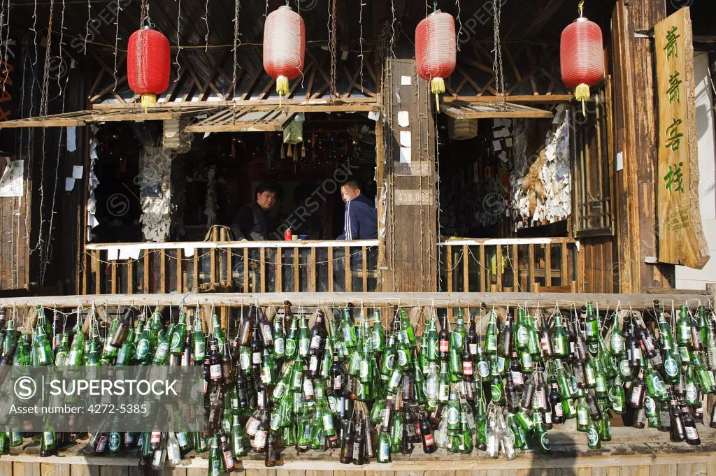 China, Hunan Province, Fenghuang, empty beer bottle on display
