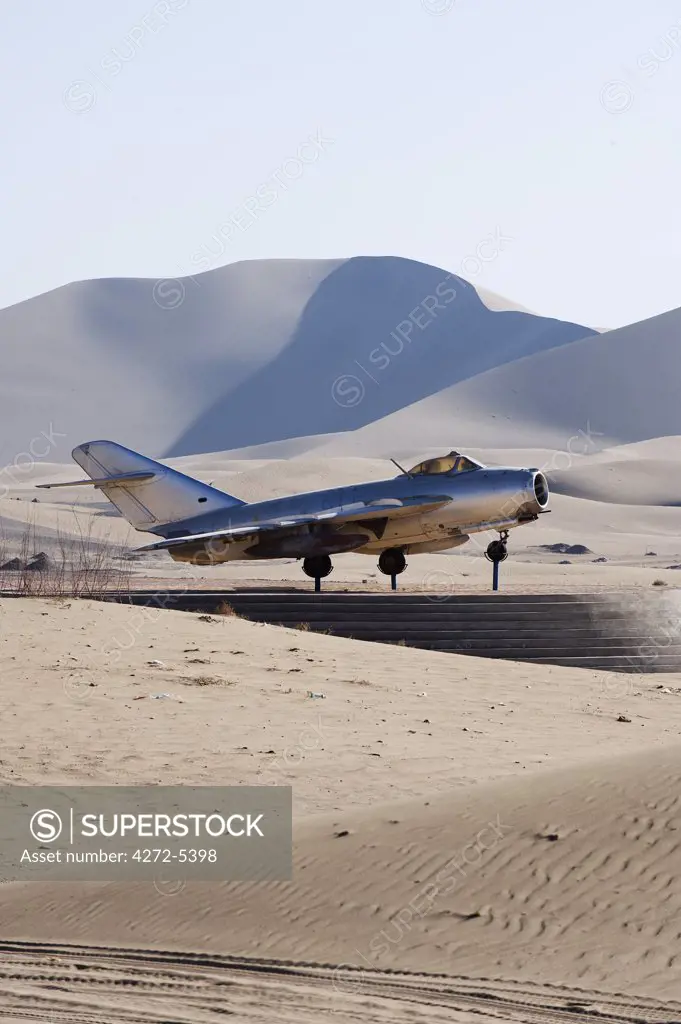 China, Gansu Province, Dunghuang, Chinese fighter plane at Ming Sha sand dunes