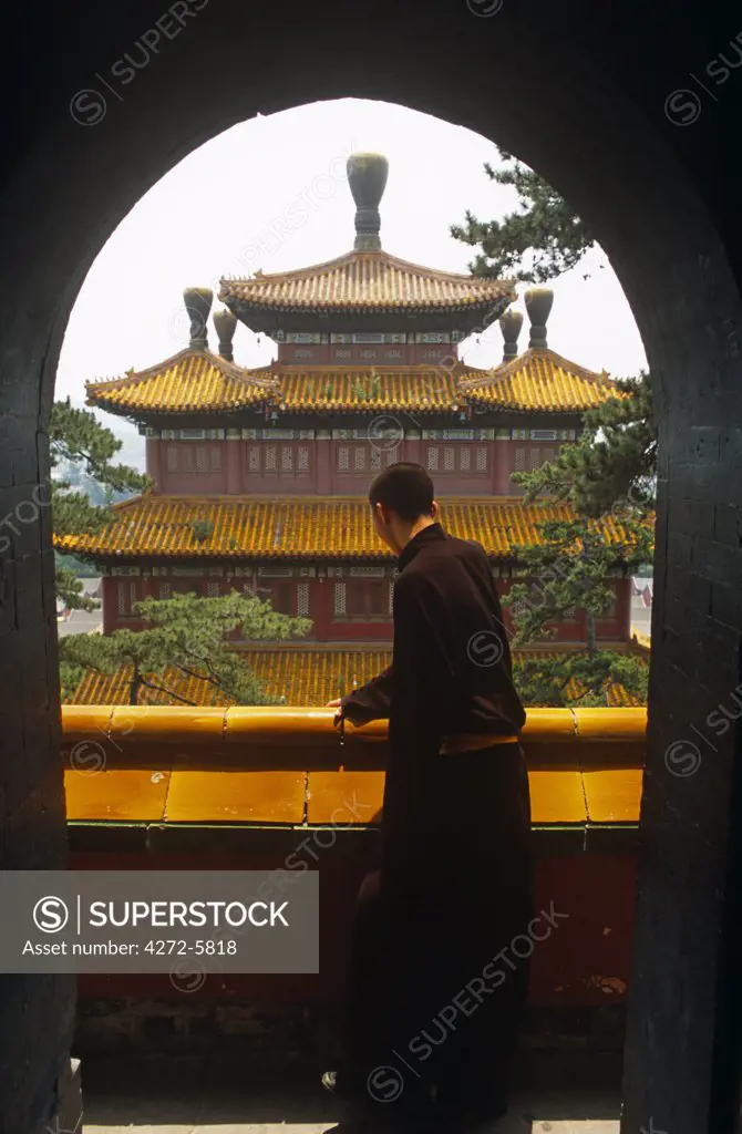China, Hebei, Chengde. A Buddhist monk gazes at the c18th Puning Si, the town's only functioning temple.