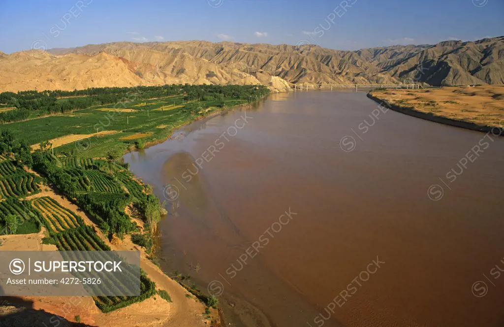 China, Ningxia Province, Zhongwei, Shapotou. Lush village fields beside the Yellow River contrast with the Tenger Desert.