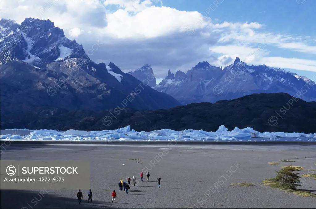 Tourists approach south end of Lago Grey with Paine Massif behind