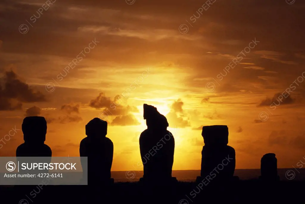 The sun sets over the Pacific silhouetting Ahu Vai Uri a ceremonial platform with four broad, squat moais and the stump of a fifth, at the ceremonial centre of Tahai.  Tahai is just a short walk from Easter Island's main settlement, Hanga Roa on the west coast of the island, backed by the Pacific Ocean.