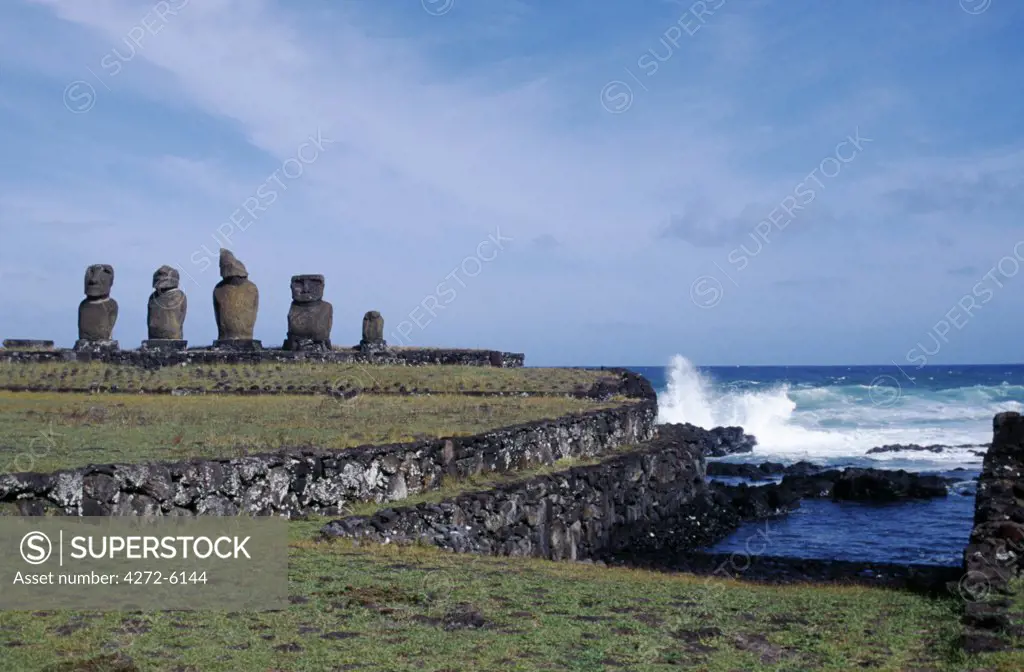 The ceremonial centre of Tahai showing the ancient stone canoe slipways and the platform of Ahu Vai Uri with its four squat moais and the stump of a fifth.  Tahai is just a short walk from Easter Island's main settlement, Hanga Roa on the west coast of the island, backed by the Pacific Ocean.