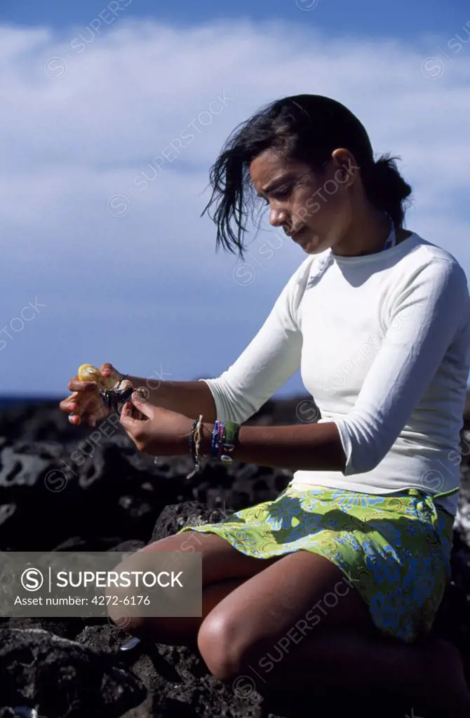 A Rapanui girl eats sea urchins that she has collected from the rocks on the coast.  Many Rapanui families go to the coast on a Sunday to fish, collect sea urchins and have a barbeque