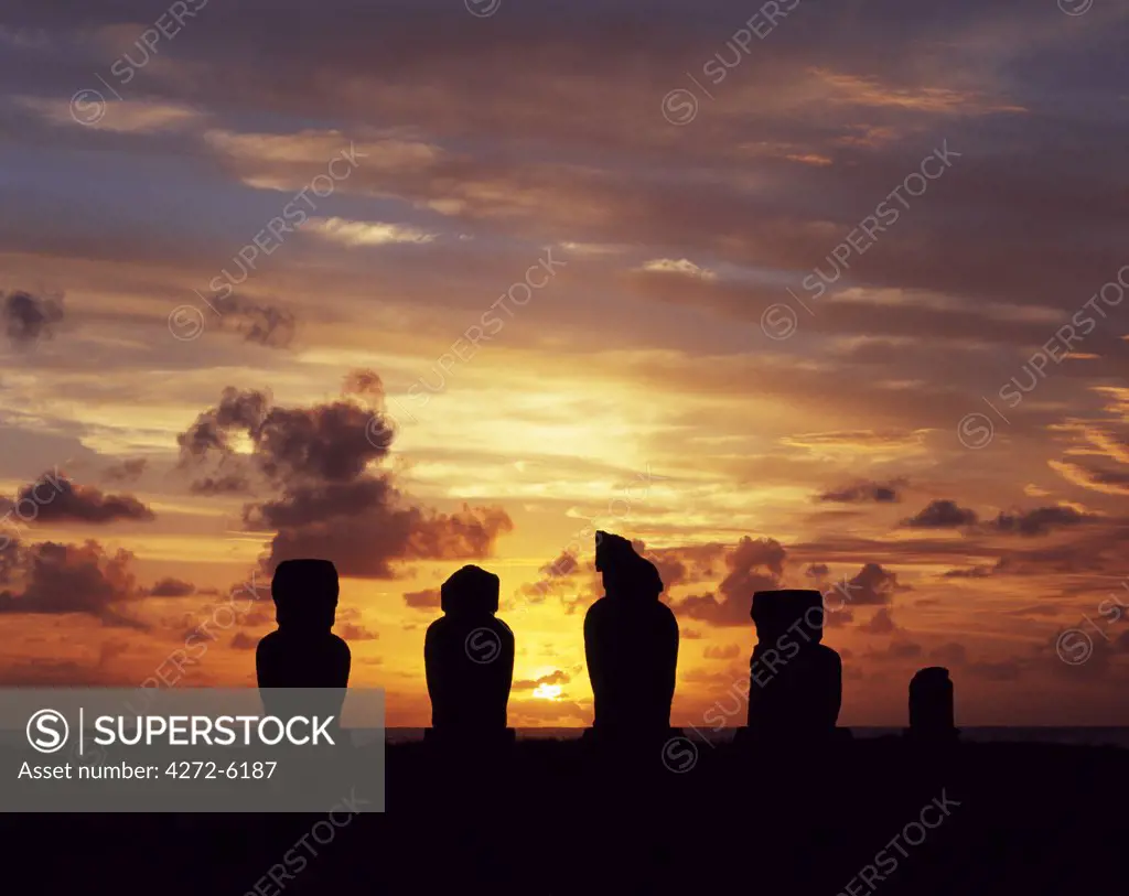 Silhouetted at sunset on Ahu Vai Uri, four weathered moais and the broked stump of a fifth sit on top of one of the three ahus or platforms of the ceremonial centre of Tahai.  Tahai is just a short walk from Hanga Roa, the island's main settlement.