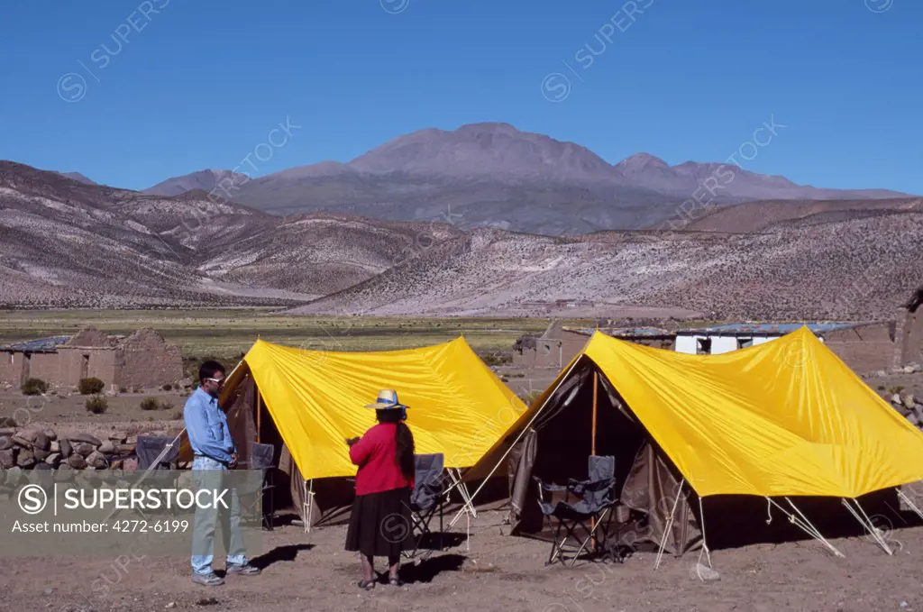 An Aymara woman talks to a tourist at Explora's tented camp in Parque Nacional Volcan Isluga
