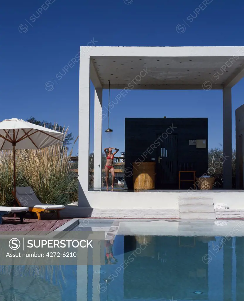 A girl takes a shower beside the sauna at one of the four swimming pools at the Explora Hotel in the Atacama Desert