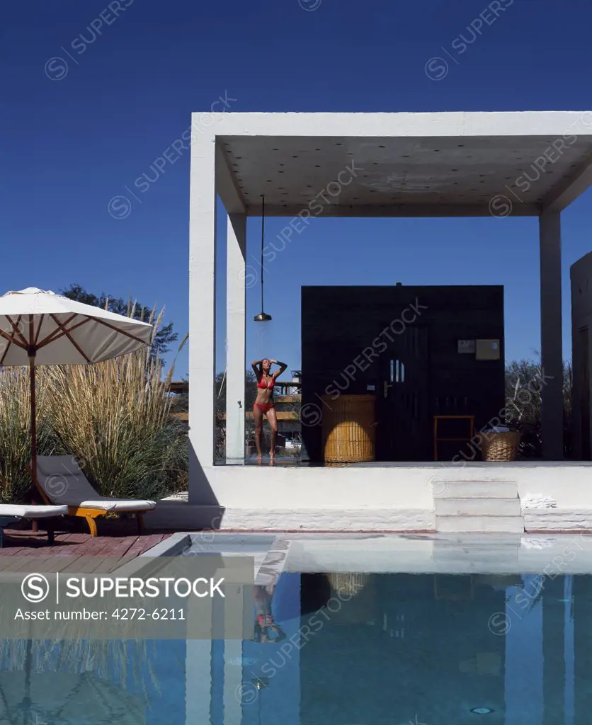 A girl takes a shower beside the sauna at one of the four swimming pools at the Explora Hotel in the Atacama Desert