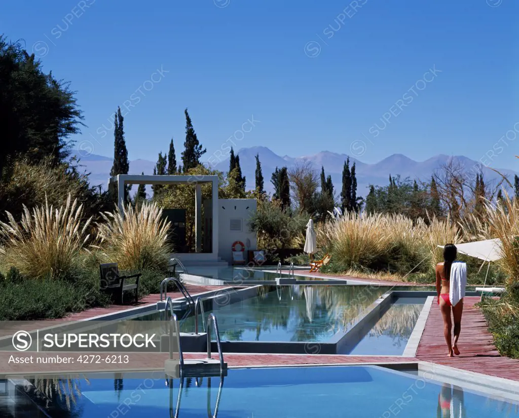 A girl walks alongside one of the four swimming pools at the Explora Hotel in the Atacama Desert