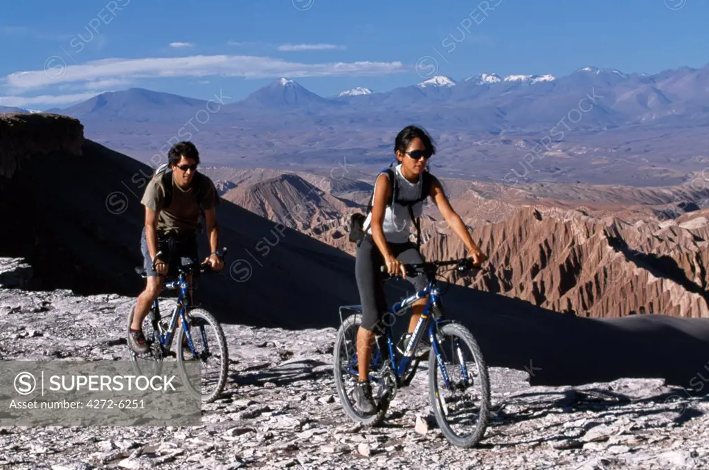Mountain biking along Las Cornicas ridge with the Salt Mountains below and the Andes in the background